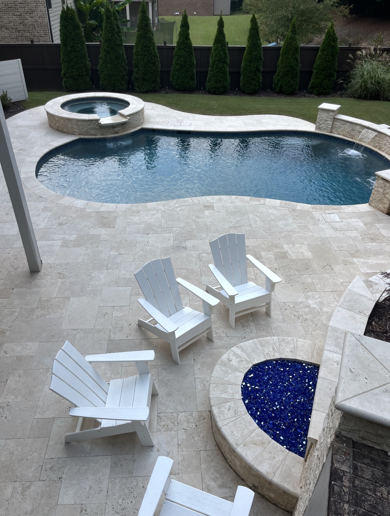 Travertine paver pool deck with raised spa and fire pit
